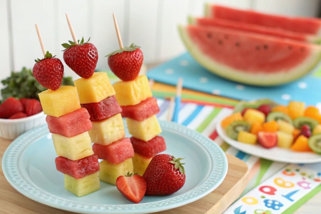 Fresh fruit kabobs with watermelon, pineapple, and strawberries on skewers.